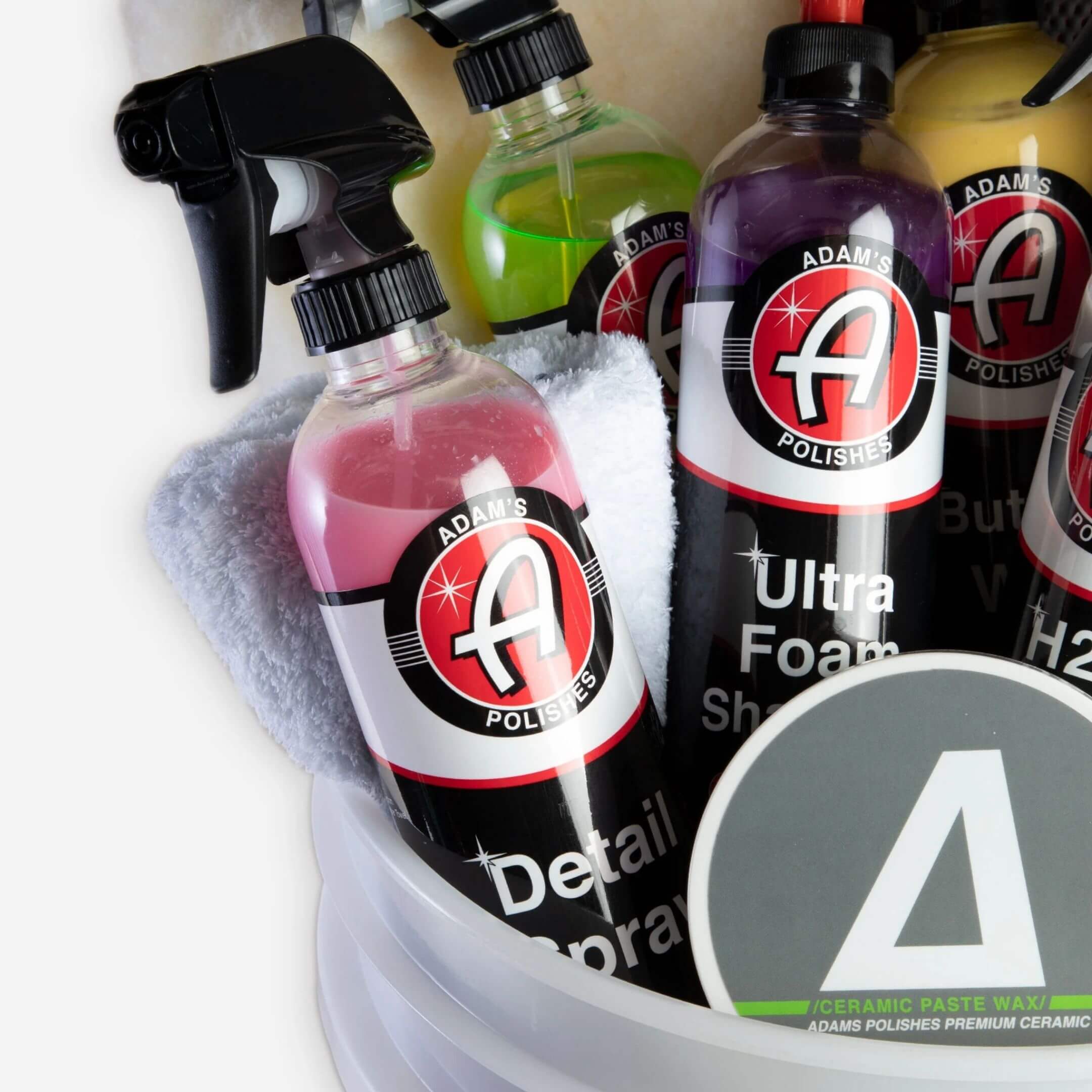 Car detailing kit featuring Adam’s Polishes detail spray, ultra foam shampoo, and microfiber towels in a bucket for a complete cleaning and shine solution.