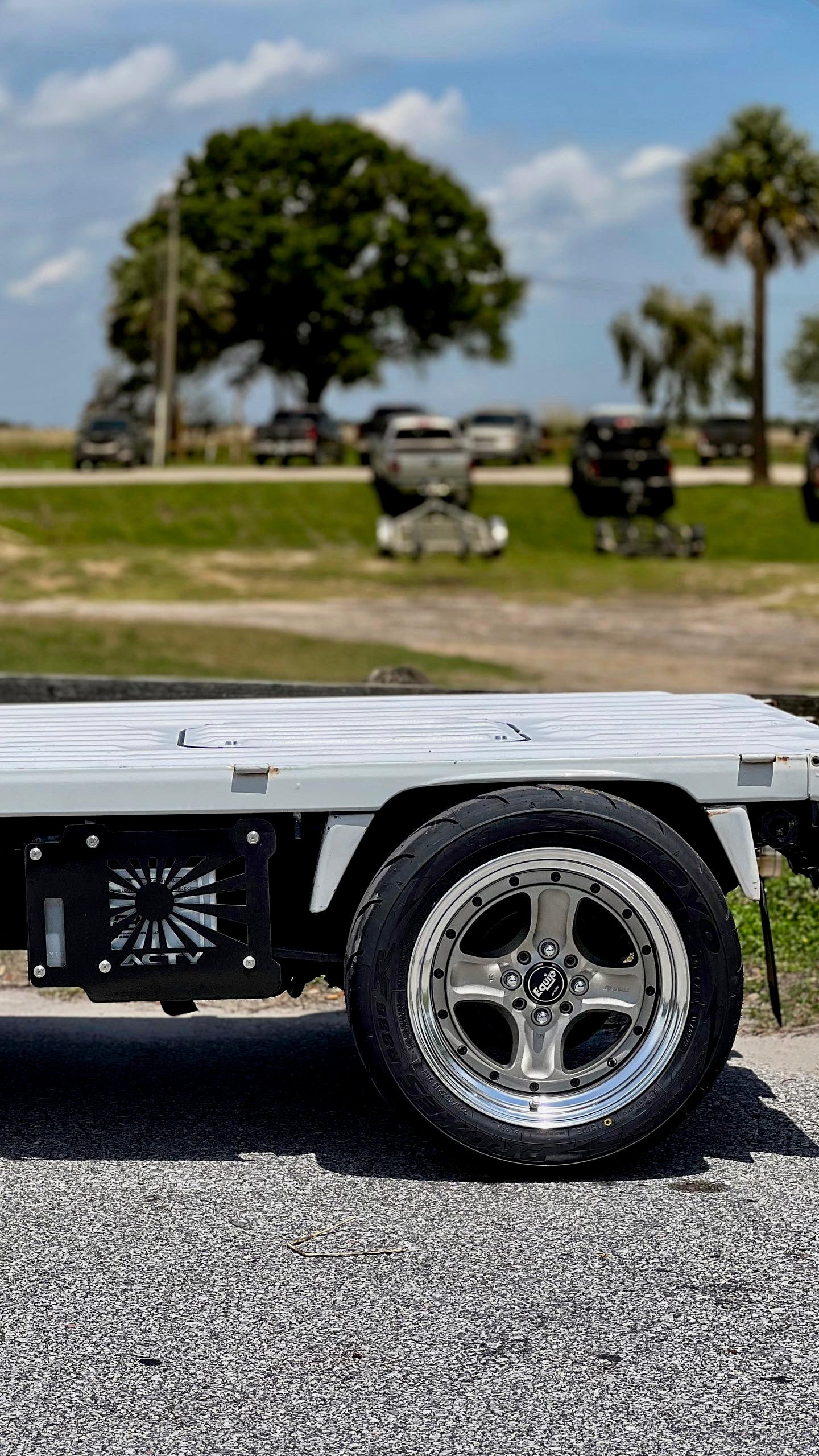 Honda Acty mini truck with air suspension, showing a lowered front profile with aftermarket wheels for a customized look.