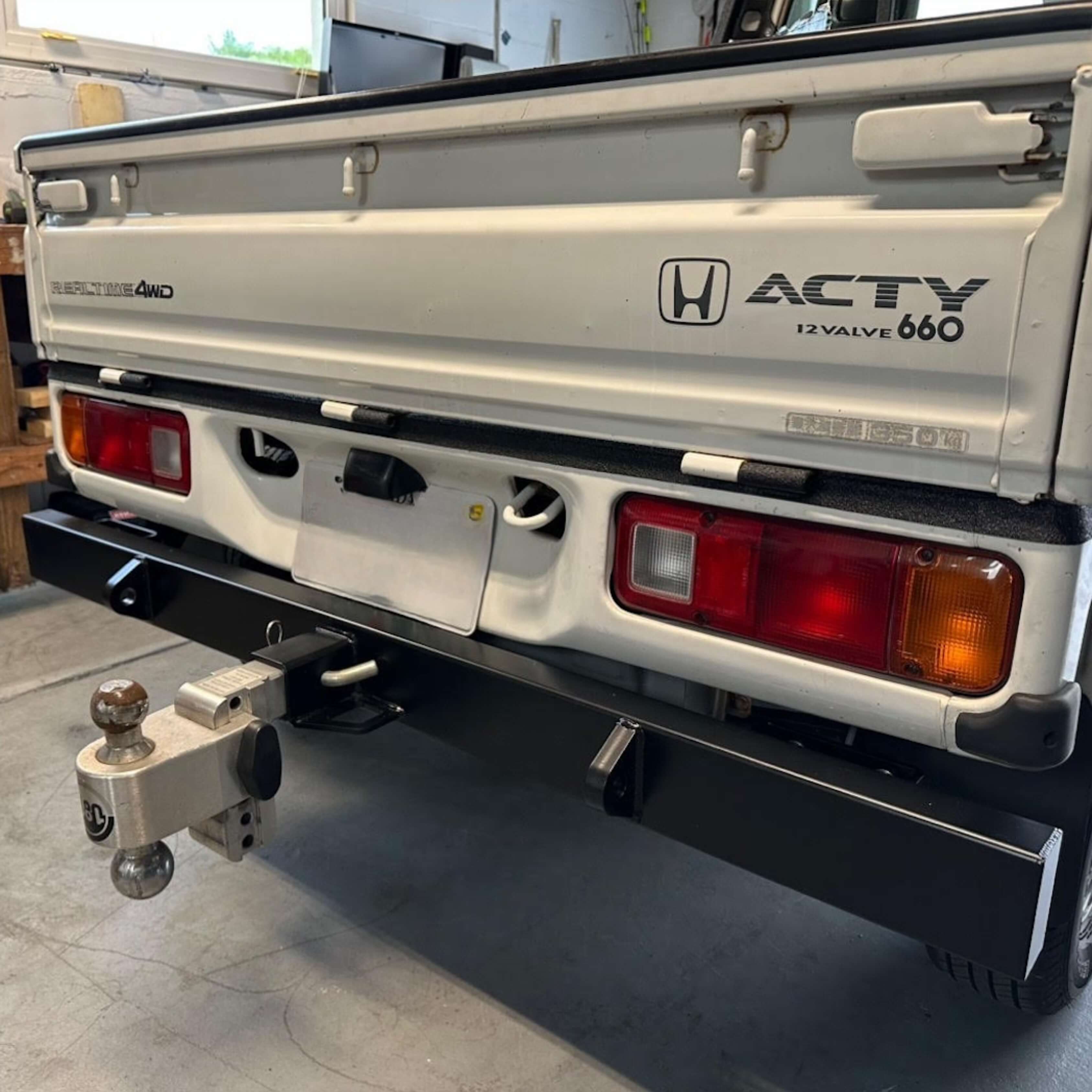 Rear tow bumper on Honda Acty Truck HA4 model in a garage setting, showing precise installation and fitment