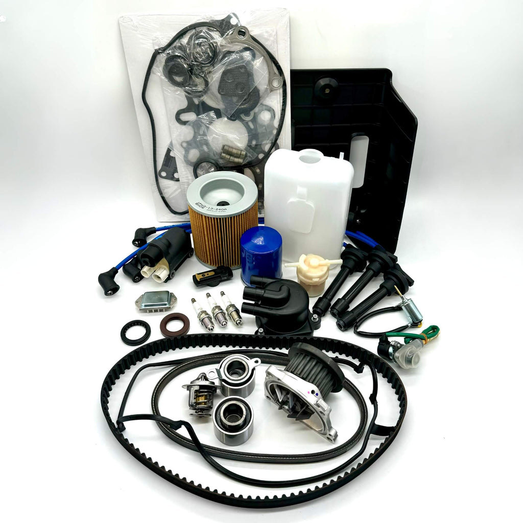 Comprehensive 25-piece Honda Acty HA3/HA4 timing belt and tune-up kit including air, fuel, and oil filters, distributor cap and rotor, spark plugs and wires, ignition control module and coil sensor, ignition assembly, engine gasket set, belts, coolant reserve tank, and battery cover for 1990-1999 models, meticulously packaged for peak performance and free shipping from Oiwa Garage.