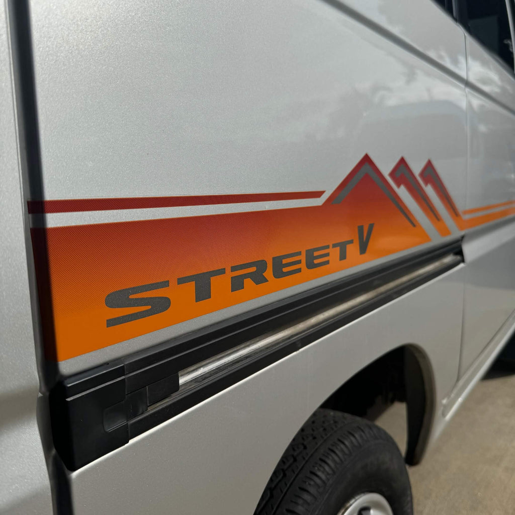 Close-up of the orange Street V side decal on a Honda Street Van HH3 or HH4 model, emphasizing the vibrant color and sharp design for a retro Japanese kei van look.