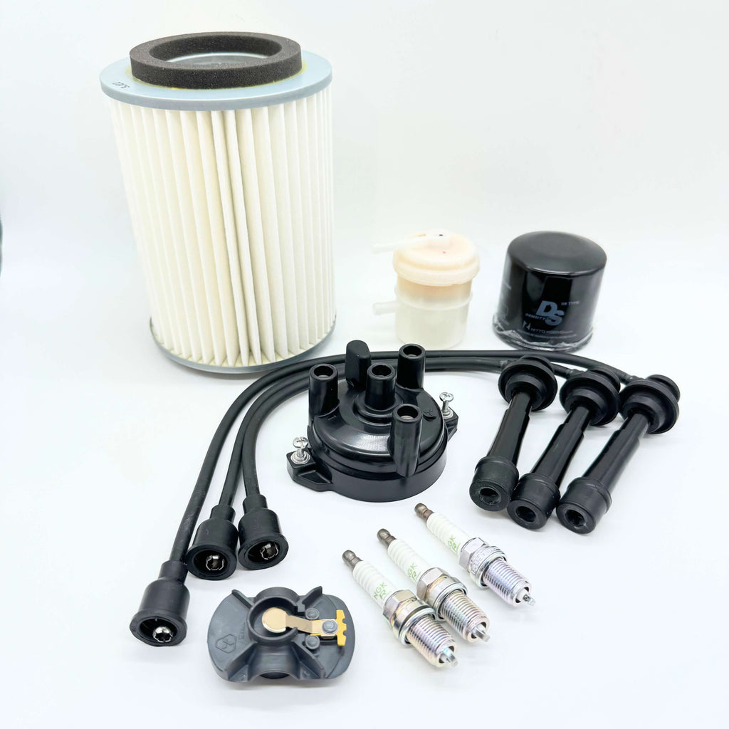 Complete ignition tune-up kit for Suzuki Carry Truck DC51T, DD51T 1991-1998, including high-quality distributor cap, durable spark plugs, flexible spark plug wires, oil filter for engine protection, fuel filter for clean fuel supply, and air filter for optimal air intake.