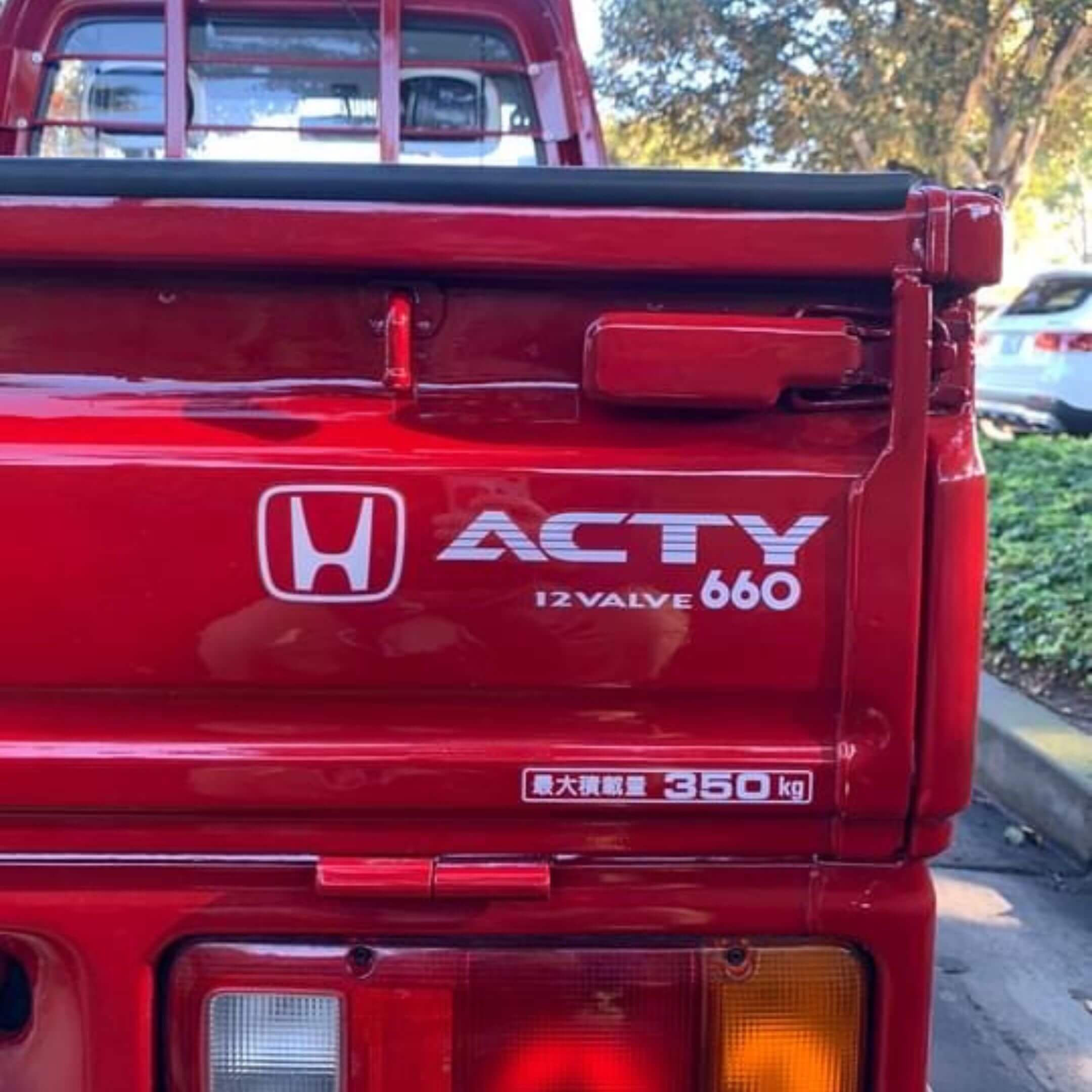 Rear view of red Honda Acty displaying the Honda logo and details about the 12 valve 660 engine capacity, ideal for specification-focused product listings.