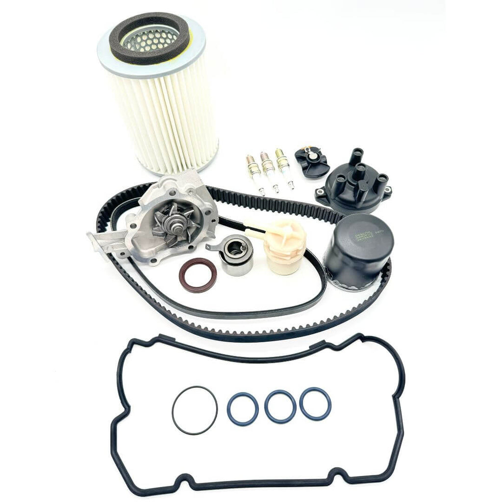 18-piece Timing Belt Kit for Suzuki Carry DC51T and DD51T (1991-1998), including timing belt, alternator belt, water pump, pulley, cam seal, valve cover gasket, filters, spark plugs, and distributor components. Comprehensive solution for engine repair and maintenance.