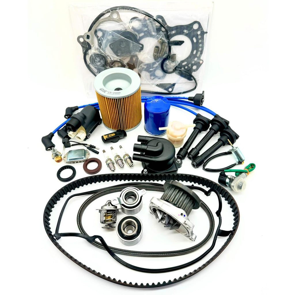 23-piece Mega Timing Belt and Tune-Up Kit for 1990-1999 Honda Acty HA3/HA4 showcased on a white background, including high-quality air and fuel filters, oil filter, distributor cap and rotor, spark plugs with wires, ignition control module with coil sensor, ignition assembly, complete engine gasket set, timing and alternator belts, and air thermal valve, available at Oiwa Garage with free shipping, ideal for vehicle maintenance and engine optimization.