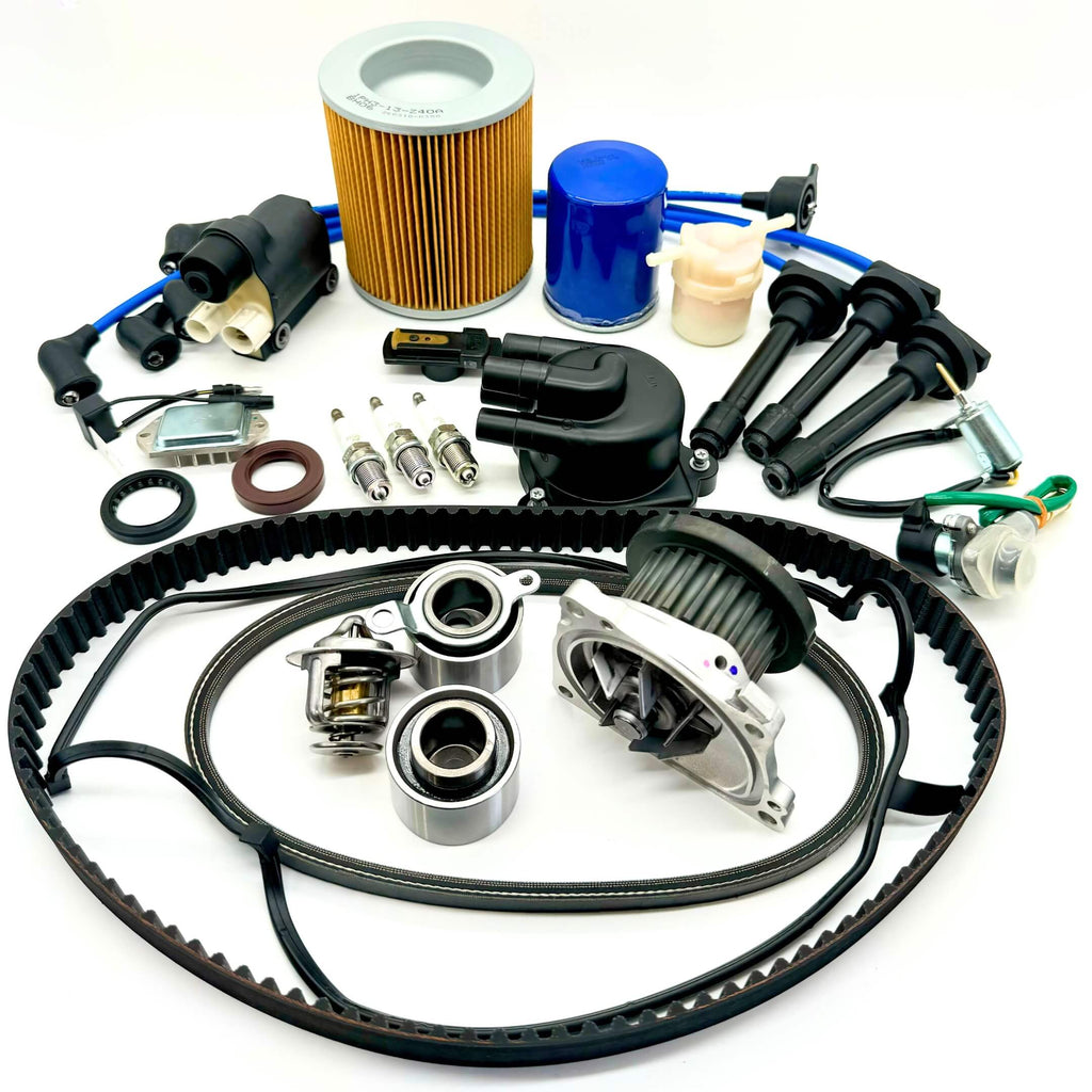 21-piece Mega Timing Belt and Tune-Up Kit for 1990-1999 Honda Acty HA3/HA4 displayed on a white background, featuring an air filter, fuel filter, oil filter, distributor cap and rotor, spark plugs with wires, ignition control module, coil sensor, ignition assembly, complete engine gasket set, and timing and alternator belts, available for order with free shipping at Oiwa Garage.