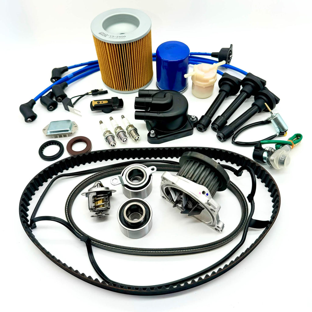 20-piece Mega Timing Belt and Tune-Up Kit for 1990-1999 Honda Acty HA3/HA4 featuring air filter, fuel filter, oil filter, distributor cap and rotor, spark plugs with wires, ignition control module, coil sensor, and complete engine gasket set with timing and alternator belts, displayed on a clean white background, available with free shipping at Oiwa Garage.
