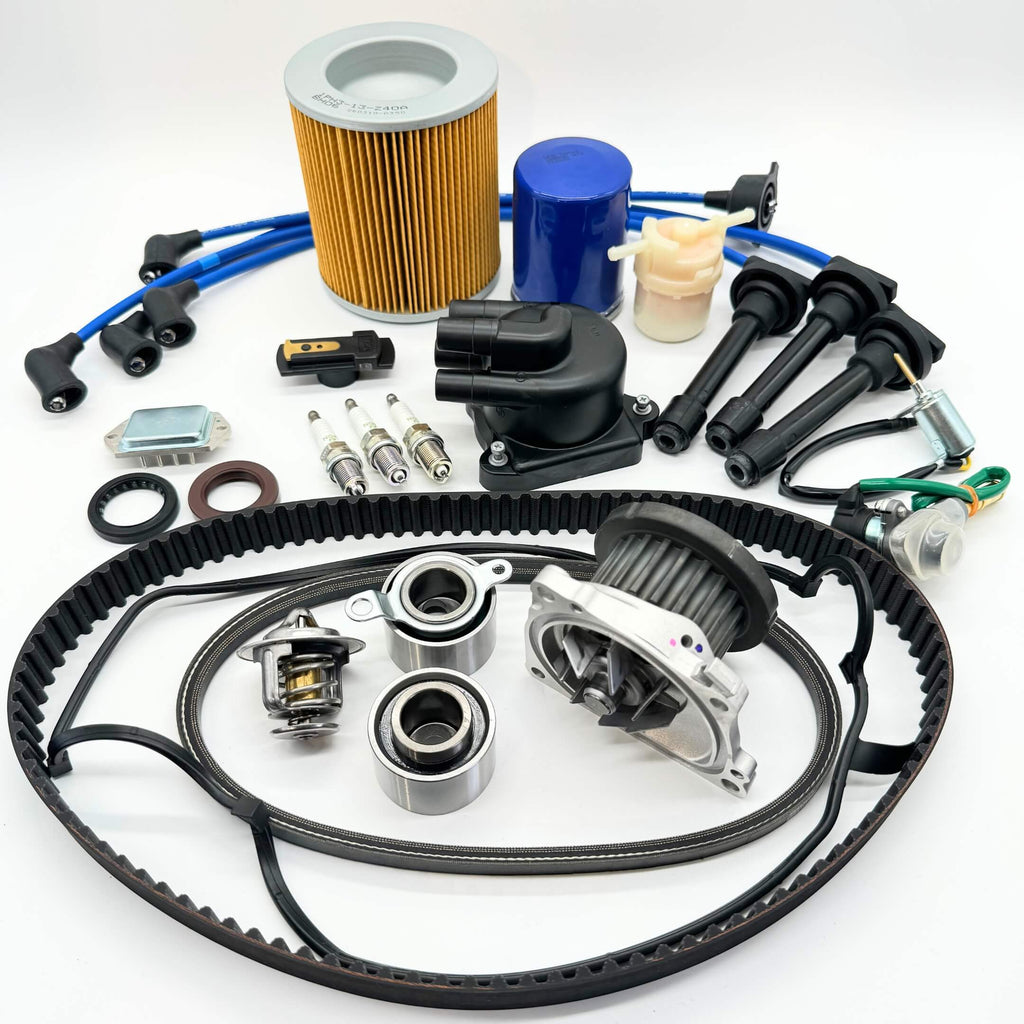 Honda Acty 1990-1999 HA3/HA4 19-piece Mega Timing Belt and Tune-Up Kit on white background, including air and fuel filters, oil filter, distributor cap and rotor, spark plugs with wires, ignition control module, coil sensor, ignition assembly, timing and alternator belts, and head gasket cover kit, available for free shipping at Oiwa Garage.