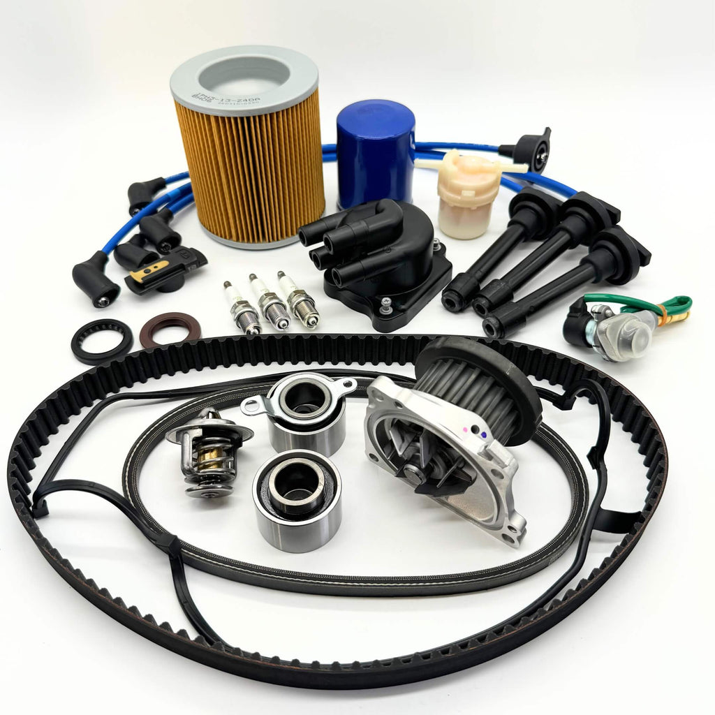 17-piece Mega Timing Belt and Tune-Up Kit for Honda Acty HA3/HA4 1990-1999, including air and fuel filters, oil filter, distributor cap and rotor, high-efficiency spark plugs with wires, timing belt, alternator belt, head cover gasket, and air solenoid, neatly displayed on a white backdrop, available for free shipping from Oiwa Garage.