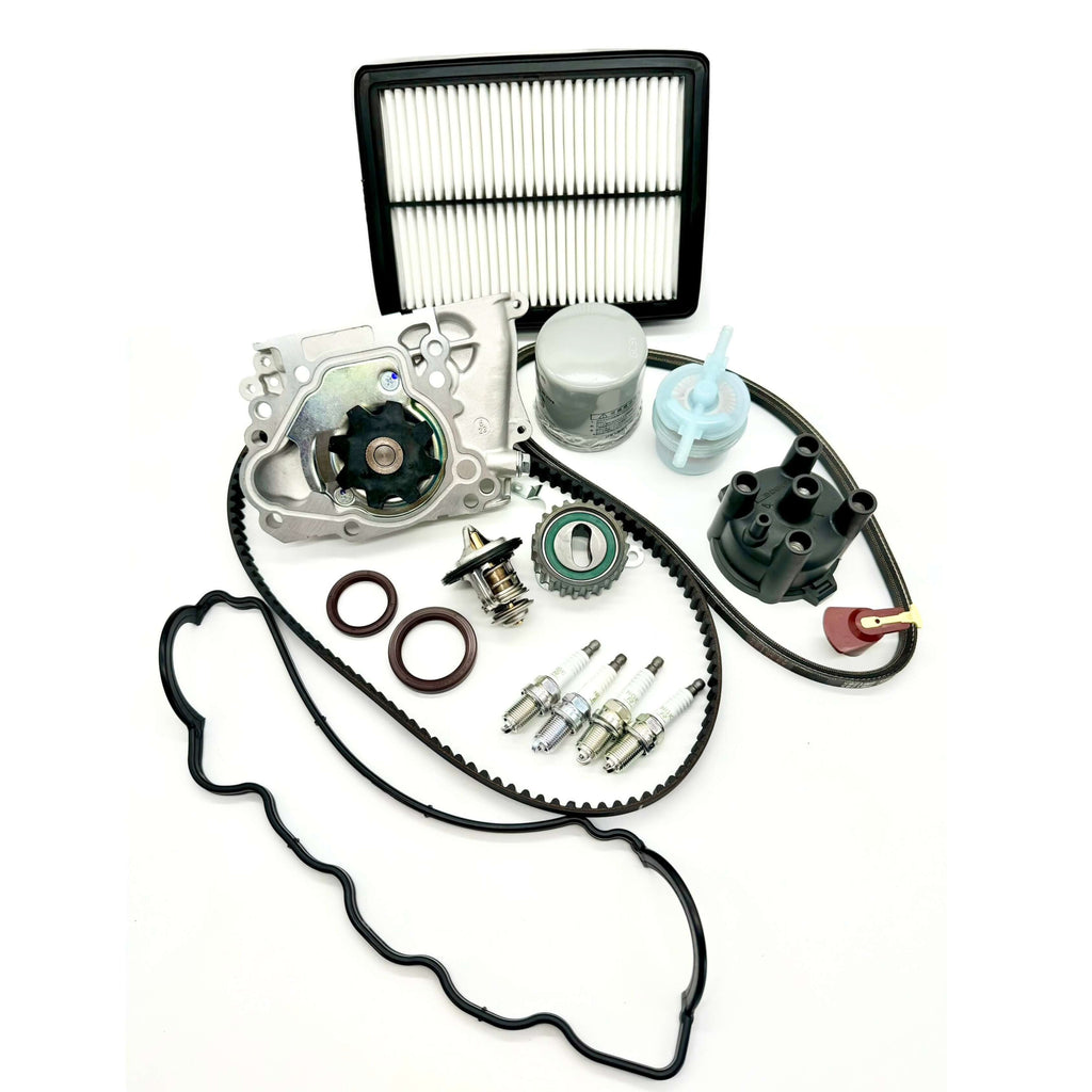 Subaru Sambar KS3 KS4 1990-1998 comprehensive 17-piece timing belt kit with timing belt, tensioner pulley, cam and crank seals, water pump, alternator belt, thermostat, valve cover gasket, oil, fuel, and air filters, spark plugs, distributor cap, and rotor for complete engine overhaul.