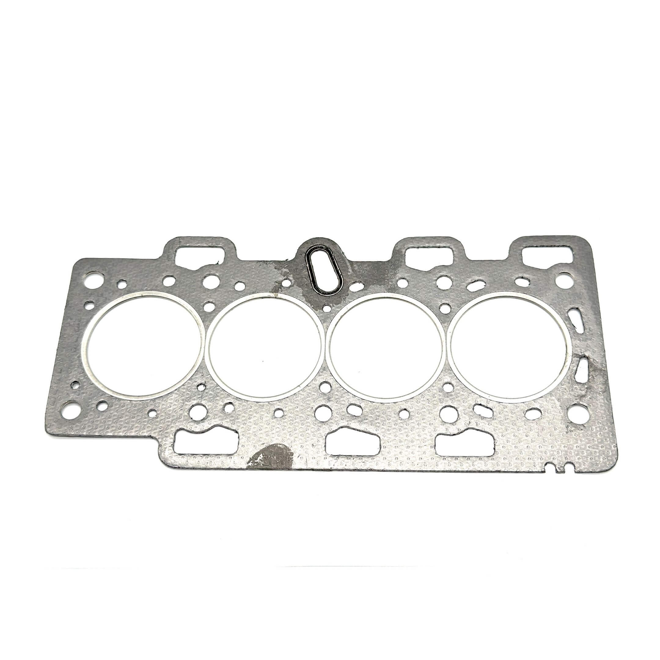 Silver cylinder head gasket for Subaru Sambar Van TV1, TV2 models (2003-2012) with multiple circular cutouts and textured surface.