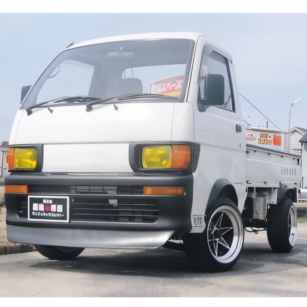 Daihatsu Hijet Truck S100P/S110P (1994–1998) white mini truck showcasing an aggressive body kit with front lip spoiler, flared fenders, side skirts, and yellow-tinted headlight covers – Body Kits Parts Collection.
