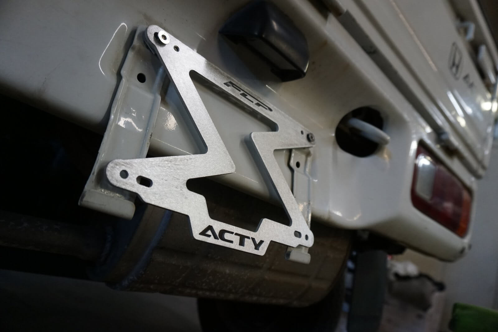 Plug and play Honda Acty license plate mount, showing the perfect fit on the vehicle's front, with a hand-finished D8 orbital sander surface for models 1980-1999.