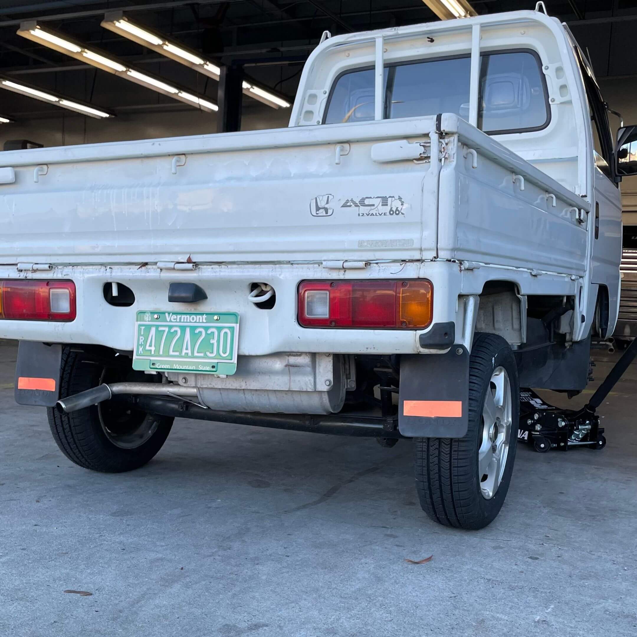 Rear angle of 1994 Honda Acty Town Kei Truck with Vermont license plate, clearly highlighting tailgate, rear lights, exhaust, and 4WD drivetrain.