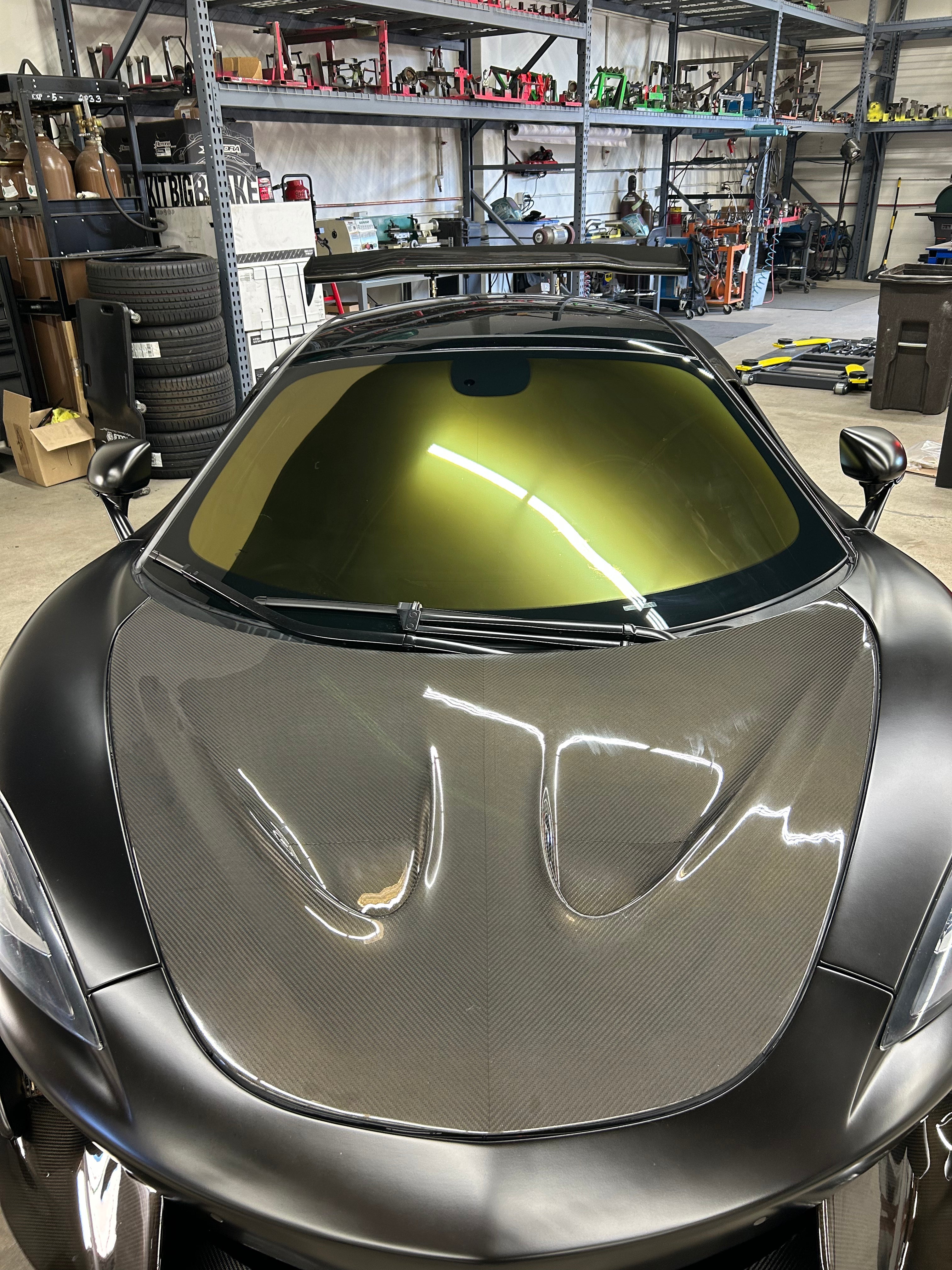 Phantom Gold mirror tint installed on a high-performance car inside a garage, featuring a bold gold reflective finish with 20% VLT, 100% UV resistance, and 85% IR resistance. Ideal for automotive enthusiasts looking to upgrade both aesthetics and protection.