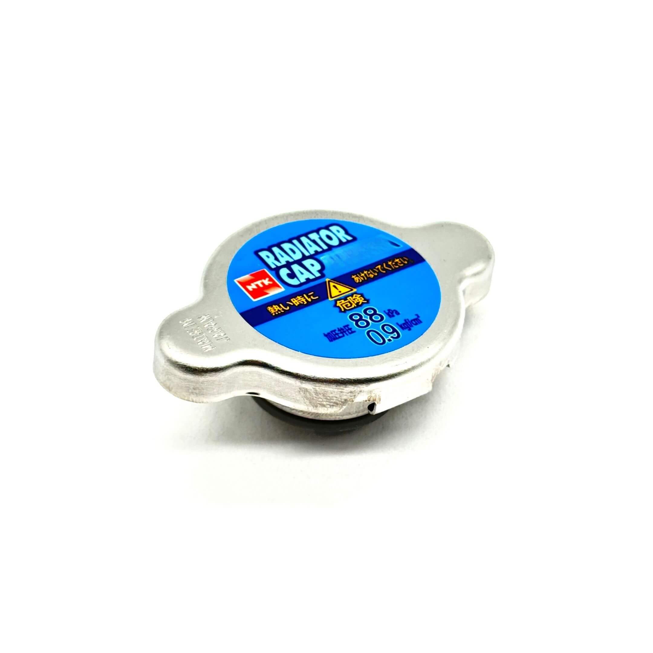 Silver aftermarket radiator cap for Subaru Sambar Truck TT1, TT2 models (1999-2012) with blue label and safety warnings.