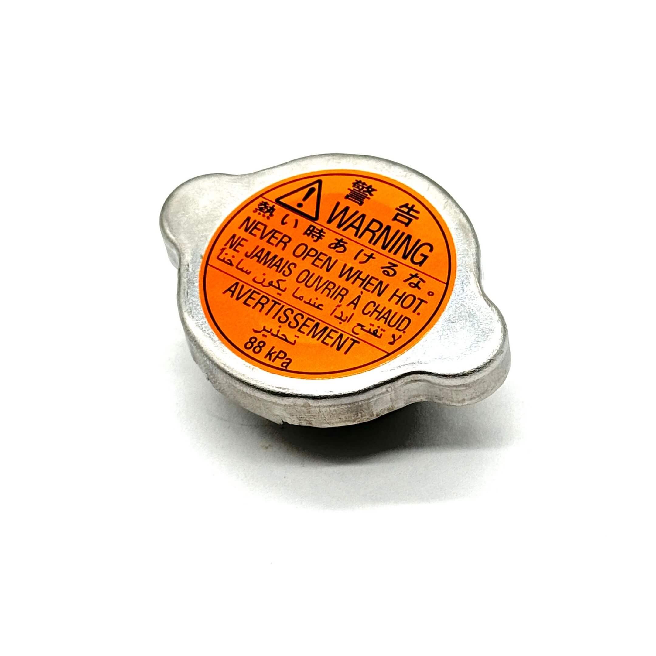 Radiator Cap for Subaru Sambar Truck TT1, TT2 Models (1999-2012), genuine part with silver finish and orange warning label, 88 kPa.