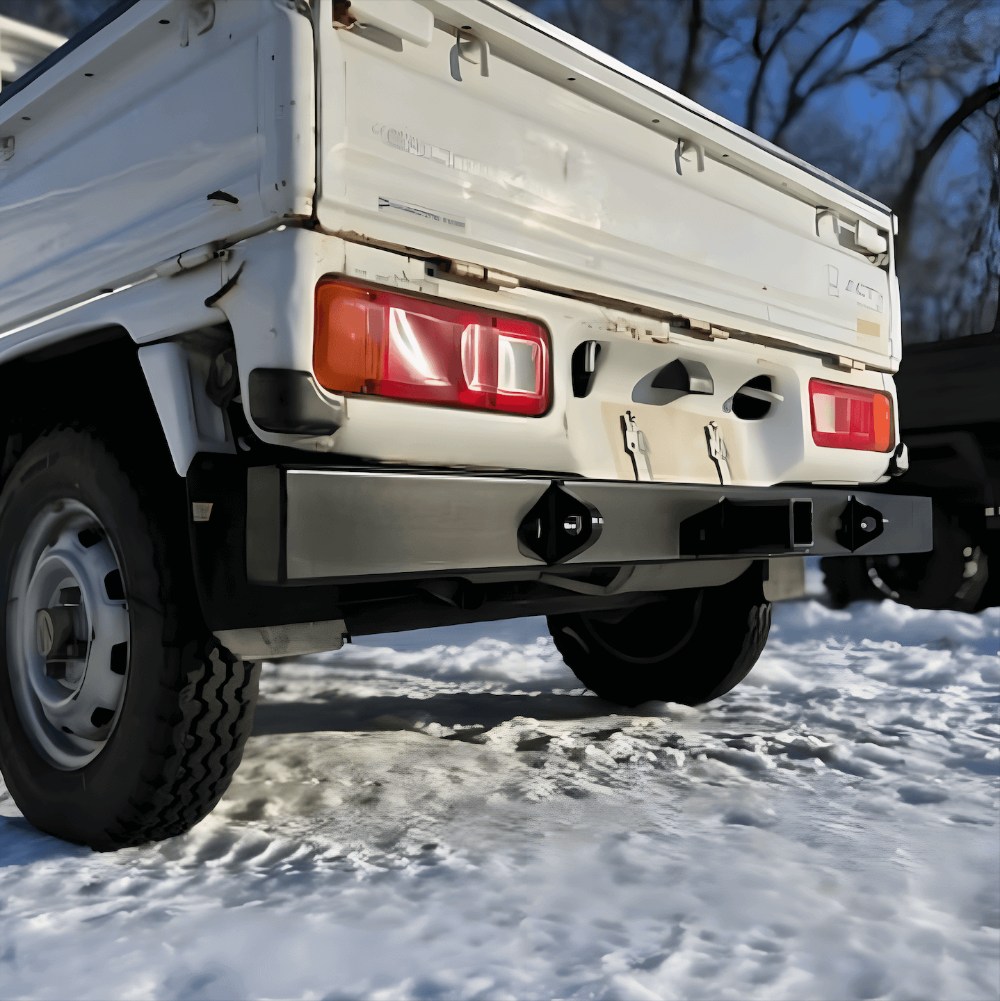 Close-up of rear tow bumper on Honda Acty Truck HA4 model in snowy conditions, highlighting robust build and design