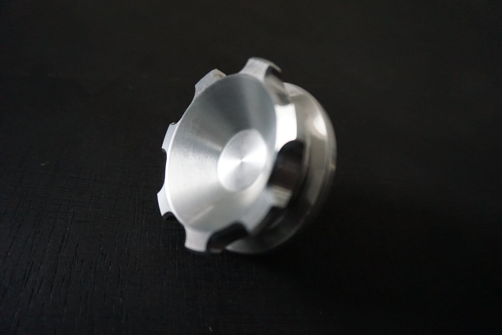 Crown gas cap for Honda Acty Truck, silver aluminum, angled view, sleek design, set against a black background