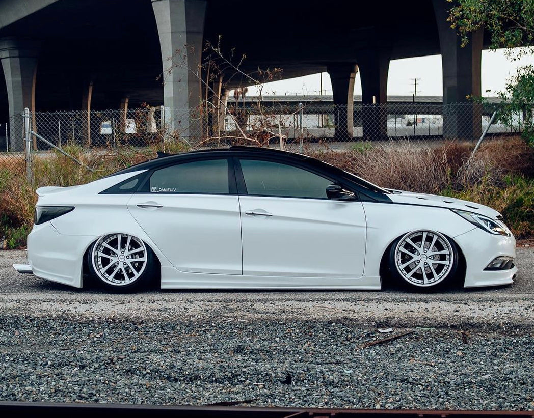 White Hyundai sedan fitted with Omnique Nebula Black tint, showcasing a flawless mirror sheen.