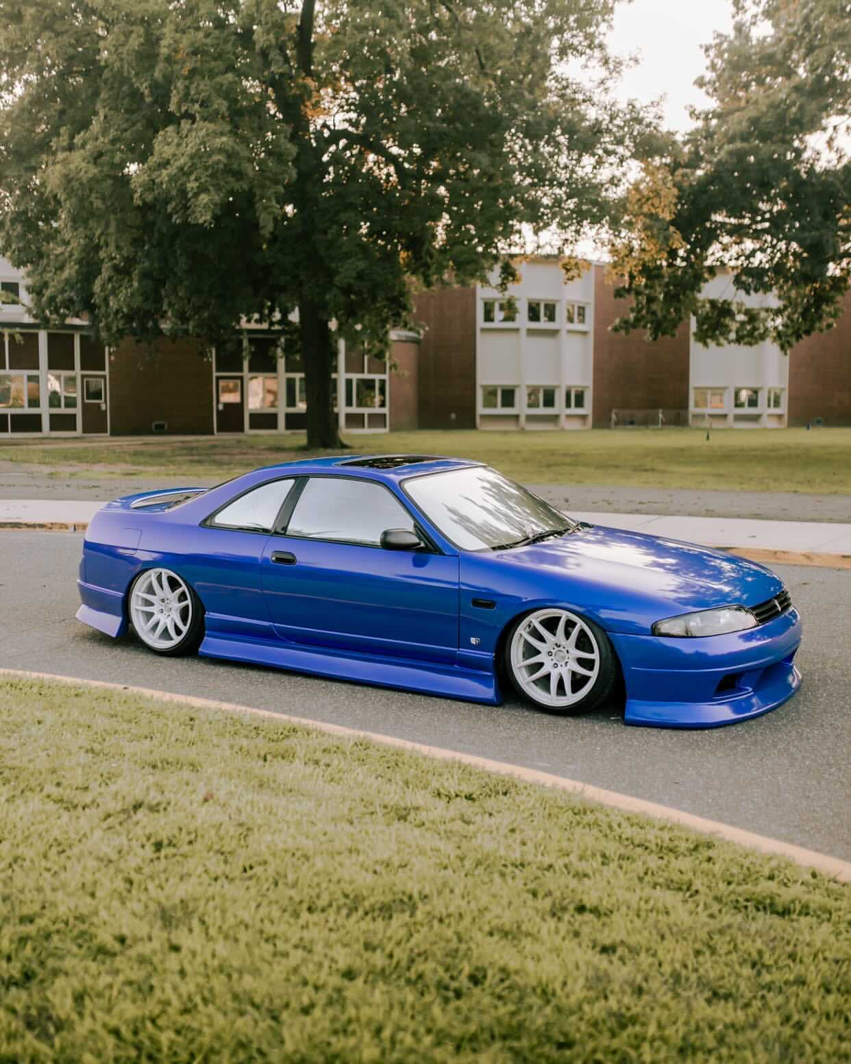 Blue Nissan skyline coupe with Neo Silver tint by Omnique, reflecting the environment with a crystal-clear mirror effect.