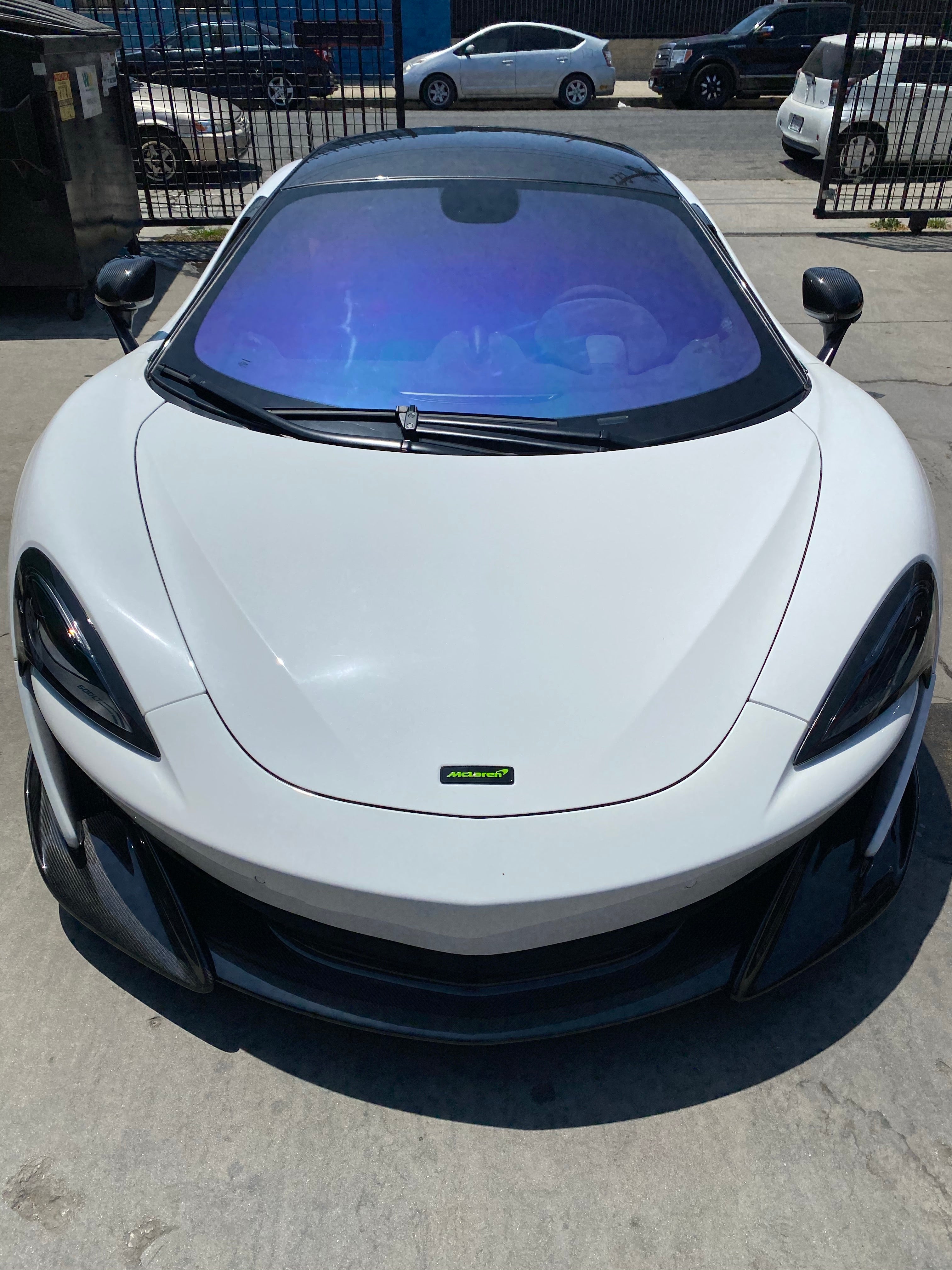 IOLITE ceramic tint by Omnique installed on a white McLaren, offering subtle blue-purple hues with a high-end finish.