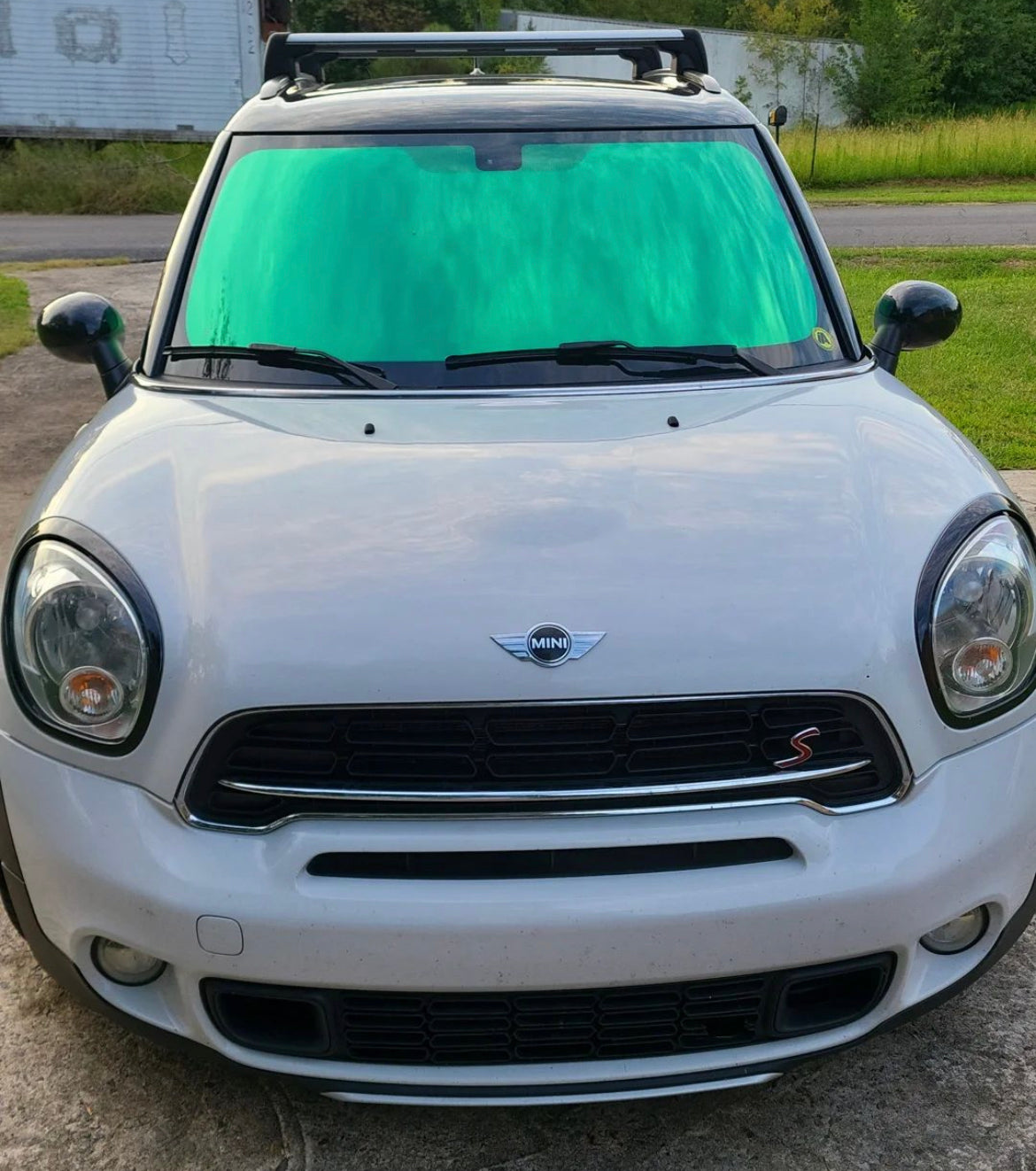 Omnique Peridot Green Tint on MINI Cooper Windshield: MINI Cooper displaying a Peridot green one-way mirror tint on the windshield for a unique green reflective finish.