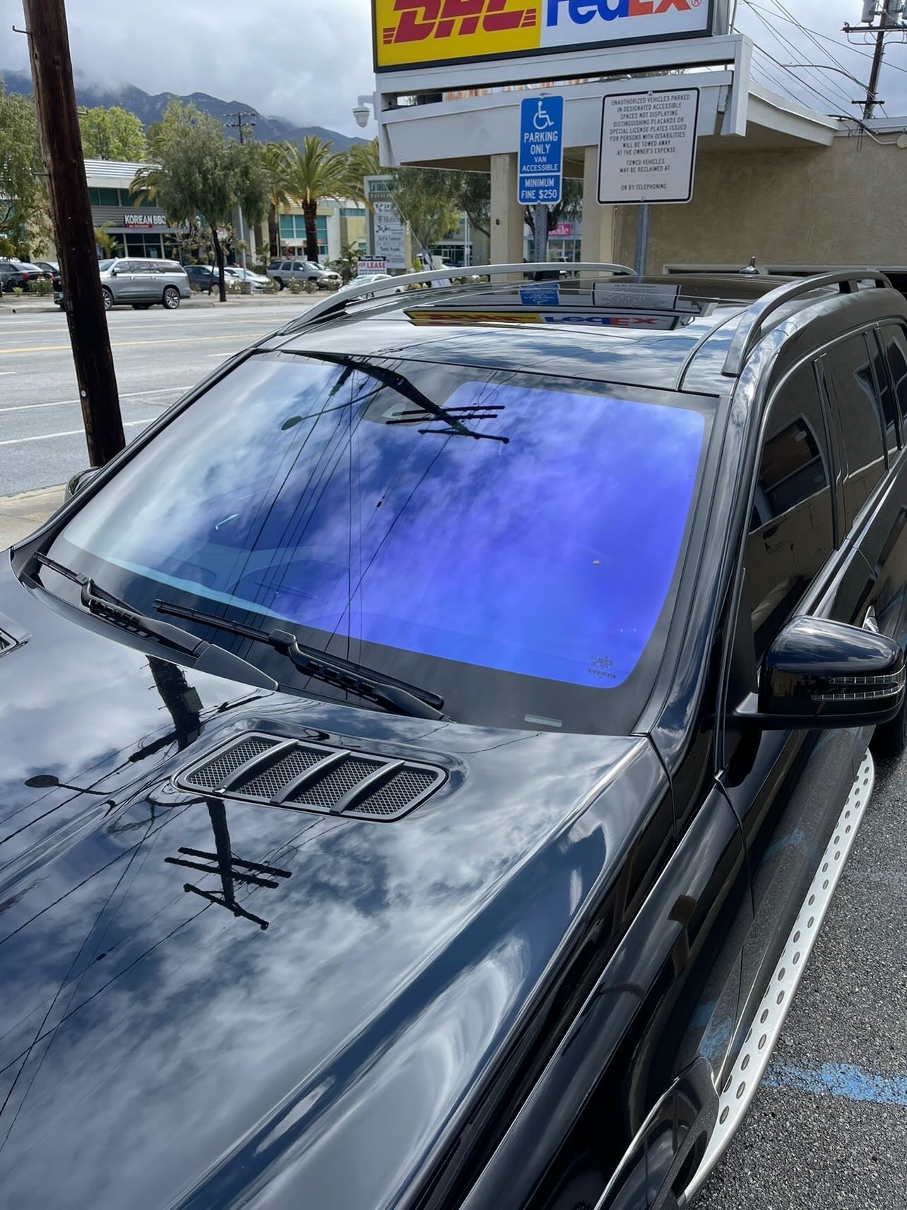 Omnique IOLITE tint on a black SUV, reflecting purple and blue shades with excellent UV protection.