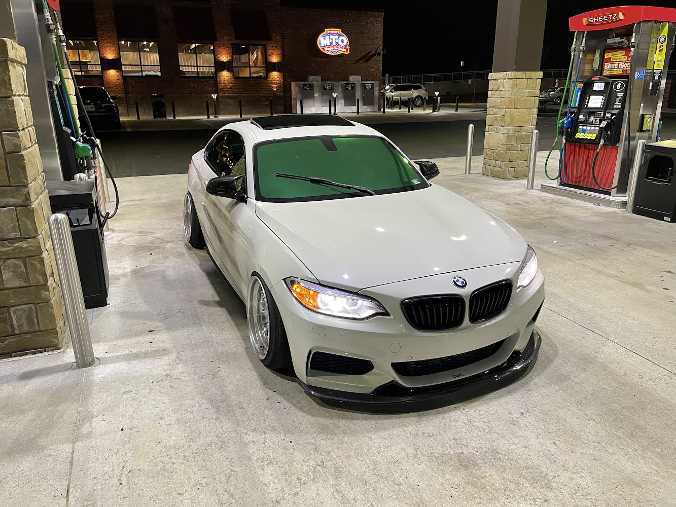 Peridot Green Tint on BMW at Gas Station: BMW coupe featuring Peridot green tint on the windshield for a bold, reflective look.