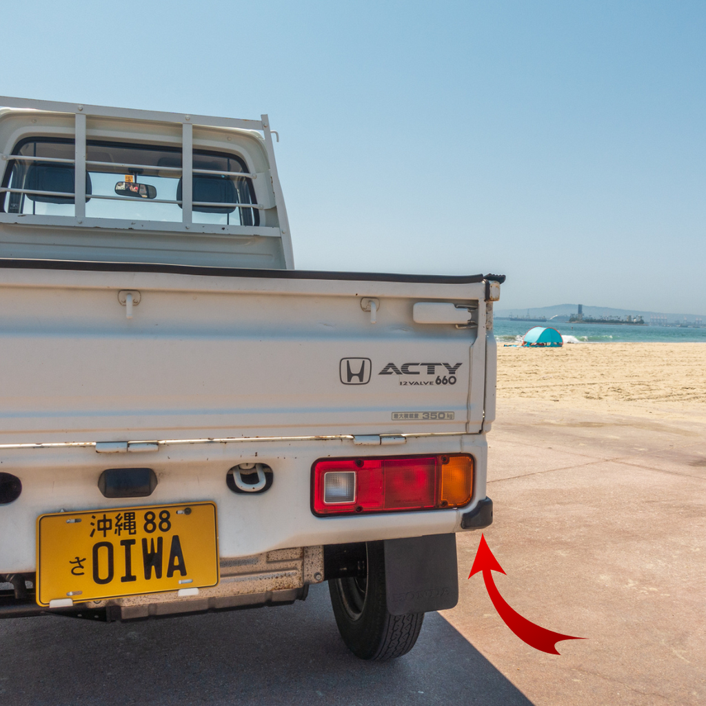 Honda Acty HA4 model rear tailgate view displaying the placement for the right side bumper cover on a sandy beach backdrop, illustrating the compatibility with Honda Acty models HA1, HA2, HA3, and HA4 from 1990-1999.